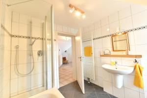 a bathroom with a shower and a sink and a toilet at Ferienwohnung am Altenlinderstall in Lindlar