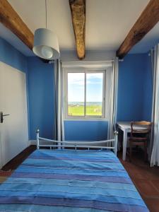 プルエスカにあるMaison reposante face à la mer avec accès plageの青いベッドルーム(ベッド1台、窓付)