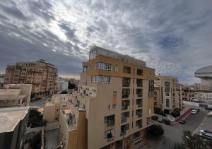 wysoki żółty budynek w mieście z budynkami w obiekcie Apartment in Sousse​ w Susie