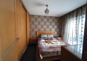 niewielka sypialnia z łóżkiem i oknem w obiekcie Apartment in Sousse​ w Susie