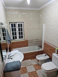 a bathroom with a sink and a toilet and a tub at Quinta Marinhais para férias no Ribatejo in Marinhais