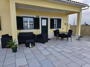 a patio with chairs and a table in front of a house at Quinta Marinhais para férias no Ribatejo in Marinhais +39 photos