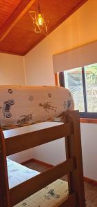 a bunk bed in a room with a ceiling at Cabaña Mandy en Lican Ray in Licán Ray +3 photos