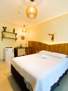 ein Schlafzimmer mit einem großen weißen Bett in einem Zimmer in der Unterkunft Residencial Mãe terra in Bombinhas