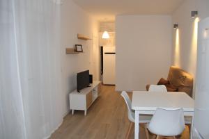a living room with a white table and a tv at Los palomares in El Casar de Talamanca