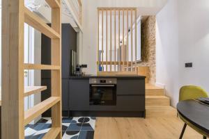 a kitchen with a black counter and a staircase at Hamac Suites - Lyon le Bellecour in Lyon