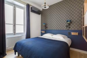 a bedroom with a blue bed and a window at Hamac Suites - Lyon le Bellecour in Lyon