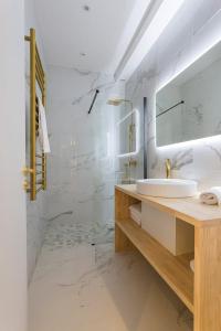 a white bathroom with a sink and a mirror at Hamac Suites - Lyon le Bellecour in Lyon