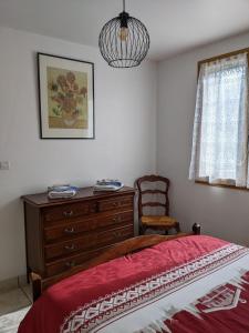 ein Schlafzimmer mit einem Bett, einer Kommode und einem Kronleuchter in der Unterkunft Gîte en montagne : La Terrasse du Rabioux in Chateauroux-les-Alpes