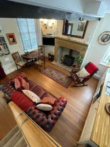 ein Wohnzimmer mit einem Sofa und einem Kamin in der Unterkunft The Little Hideaway - Historic Gem off Haworth Main Street in Haworth