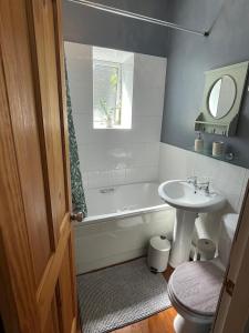 a bathroom with a sink and a tub and a toilet at The Little Hideaway - Historic Gem off Haworth Main Street in Haworth