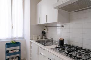 una cucina bianca con lavandino e piano cottura di San Liborio Suites a Napoli