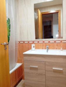 y baño con lavabo y espejo. en Confortable y nuevo cerca del Casco antiguo en Caravaca de la Cruz