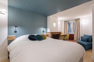 a bedroom with a large white bed with blue walls at Cocon Cordeliers / 4 voyageurs in Lyon