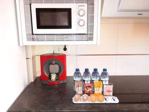 a counter top with bottles of water and a microwave at Confortable y nuevo cerca del Casco antiguo in Caravaca de la Cruz