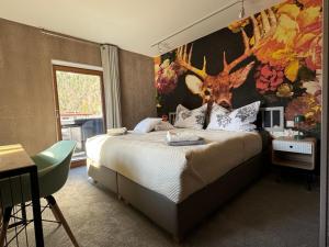 1 dormitorio con 1 cama grande con cabeza de ciervo en la pared en Two Brothers Inn en Pertisau