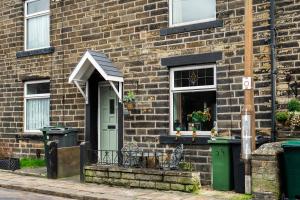 a brick house with a green door and a window at Sun Street Cottage - with log burner, jet bath and Summerhouse in Haworth