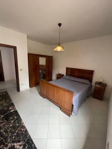 een slaapkamer met een groot bed met een houten hoofdeinde bij Casa Massa in Massa Lubrense