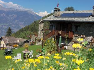 ein Haus in den Bergen mit Blumen im Hof in der Unterkunft Affittacamere Saint Salod in Charvensod