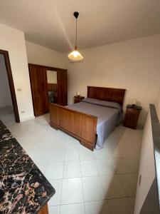 een slaapkamer met een bed met een houten hoofdeinde bij Casa Massa in Massa Lubrense