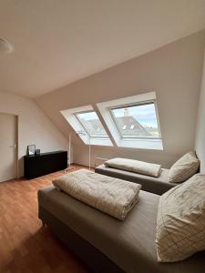a attic bedroom with two beds and two windows at urbanstays Linz Denkstraße in Linz