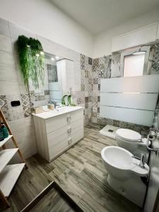 bagno con lavandino, servizi igienici e specchio di Il nido del Viaggiatore a San Giorgio Ionico