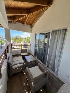 une chambre avec des chaises et des tables sur un balcon dans l'établissement Residencial Paraiso by Alex, à Bayahibe