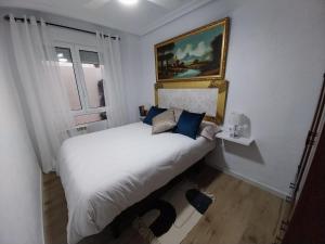 1 dormitorio con 1 cama blanca grande con almohadas azules en Apartamento Thematic OyM, en Villena