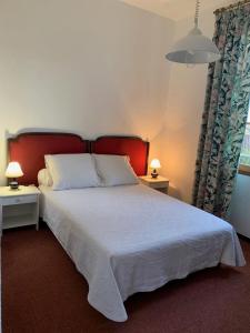 una camera con un grande letto con testiera rossa di Maison Les Mimosas a Le Rayol-Canadel-sur-Mer