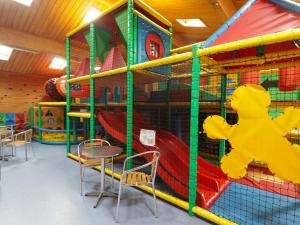 a play room with a slide and a playground at 13 Gower Holiday Village in Swansea