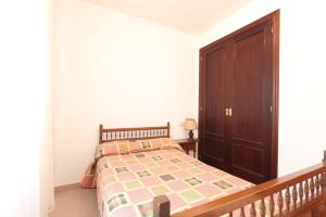 ベハルにあるApartamento CASA VETONAのベッドルーム1室(ベッド1台付)、木製キャビネットが備わります。