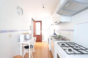 a white kitchen with a sink and a stove at Apartamento CASA VETONA in Béjar