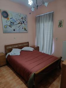 um quarto com uma cama com uma colcha vermelha em PS House Amfikleia - PS Rental em Amfikleia