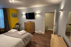 a bedroom with a bed and a tv on the wall at Seaside Hideaway - Free Onstreet Parking in Scarborough