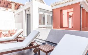 a balcony with chairs and tables on a building at Pink Mango in Athens