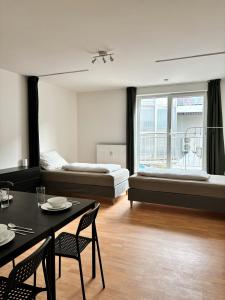 ein Wohnzimmer mit einem Bett, einem Tisch und Stühlen in der Unterkunft urbanstays Linz Denkstraße in Linz
