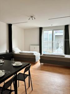 a living room with a bed and a table and chairs at feworld living Linz Denkstraße in Linz