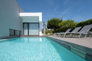 una piscina con sillas y un edificio en Bela Vista da Luz 17 by Destination Algarve, en Luz