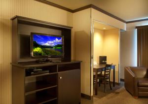 una habitación de hotel con TV de pantalla plana en una habitación en Motel Idéal Ste-Rose en Laval