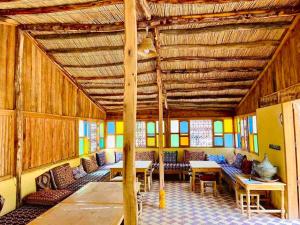 ein Zimmer mit Tischen und Stühlen in einem Gebäude in der Unterkunft Camping auberge palmeraie d'amezrou in Zagora