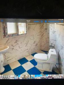 een badkamer met een wit toilet en een wastafel bij Vacancia in Douar Chaïb Rasso
