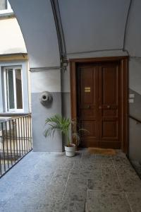 una porta con una pianta in vaso davanti di San Liborio Suites a Napoli