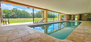 a swimming pool in a house with a large window at PETIT PARADIS 24 in Groléjac +36 photos