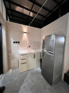 La cuisine est équipée d'un réfrigérateur en acier inoxydable et d'un évier. dans l'établissement استراحة غزل, à Médine