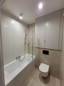 y baño con bañera, aseo y ducha. en Dream Rent Apartament Superior, en Łódź