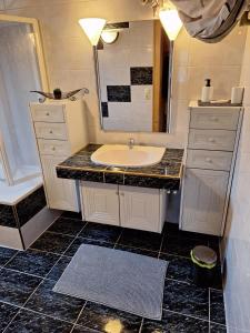 a bathroom with a sink and a mirror at Lechapart Wagner in Reutte +46 photos