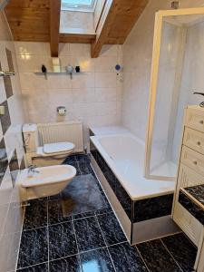 ein Badezimmer mit einer Badewanne, einem WC und einem Waschbecken in der Unterkunft Lechapart Wagner in Reutte