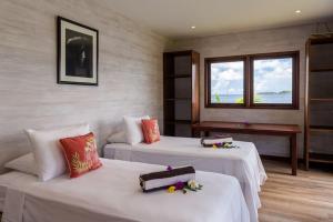 Habitación con 2 camas y ventana en Villa Kahaia Bora Bora, en Bora Bora