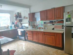 a kitchen with wooden cabinets and a counter top at Bryslaungeguayaquil in Guayaquil