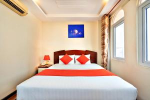 a bedroom with a large bed with red pillows at HANZ The Beautiful Hotel Bui Vien Walking Street in Ho Chi Minh City